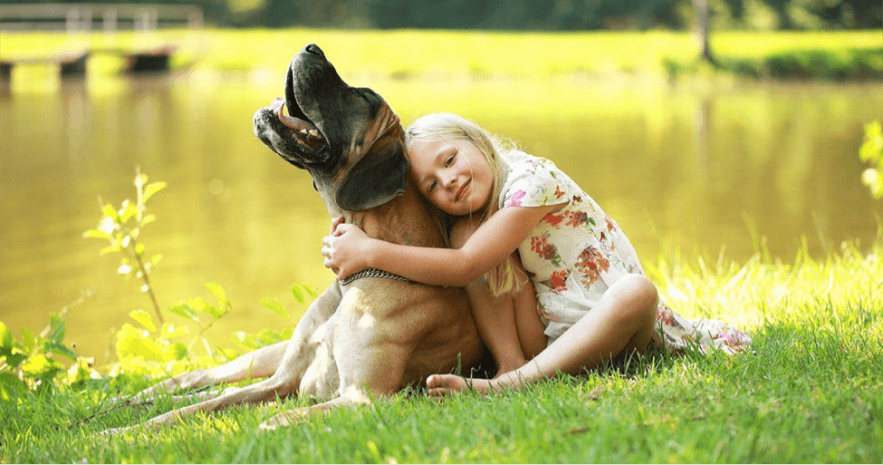 Girl Hugging Dog by a Lake