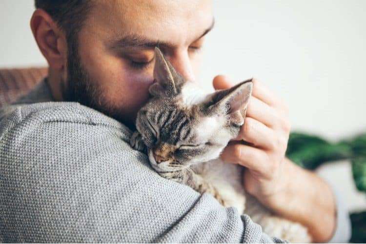 Man cuddling his adult cat